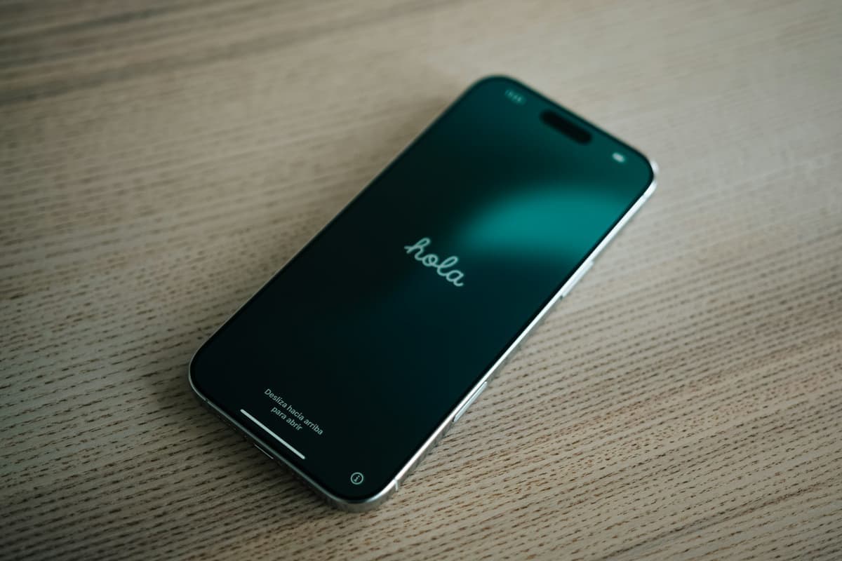 A phone lying on a wooden desk showing the welcome screen that follows a factory reset